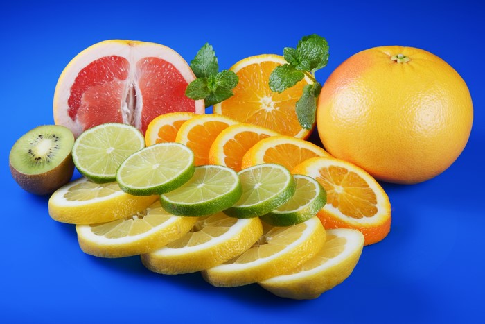 Assortment of citrus fruits and kiwi on a blue background