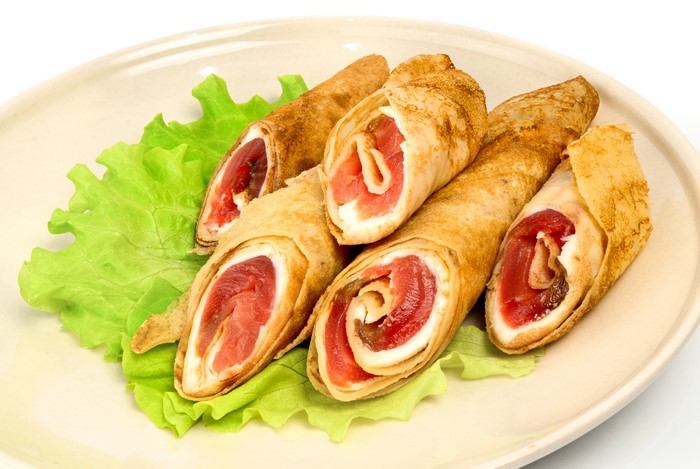 Pancakes with fish and cream cheese on lettuce