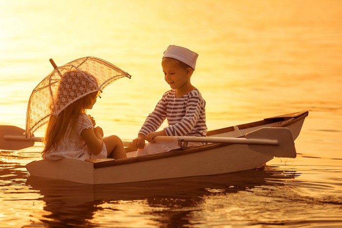 Children in a rowboat at sunset