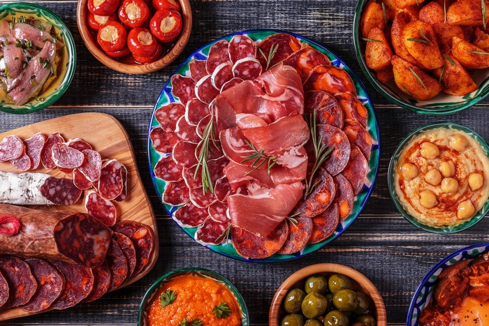 Charcuterie board with cured meats, olives, and roasted potatoes