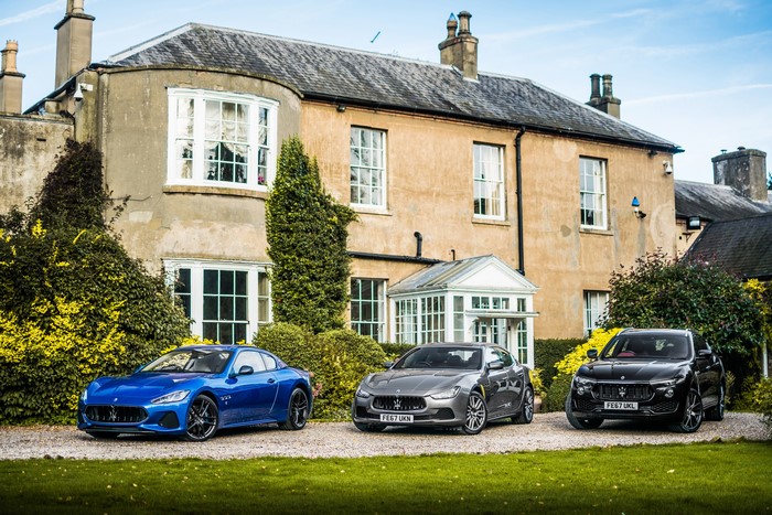 Three Maserati cars parked in front of a house