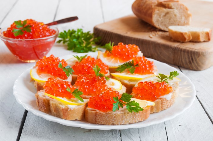 Red Caviar Appetizers on Bread with Lemon and Parsley