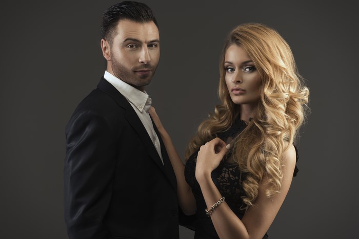 Man in Suit and Blonde Woman on Gray Background
