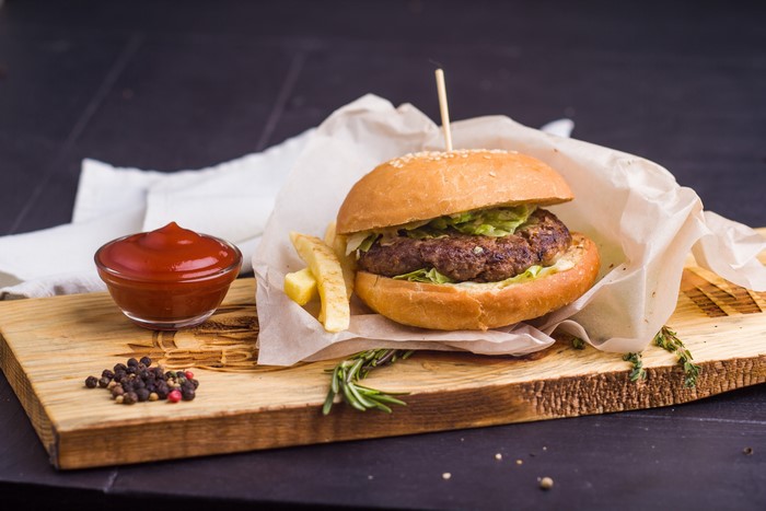 Hamburger with Ketchup on a Cutting Board