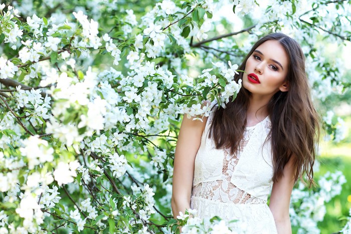 Woman in white dress among flowering trees