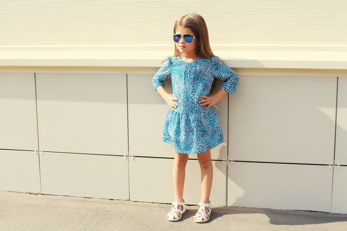 Little girl in blue dress and sunglasses