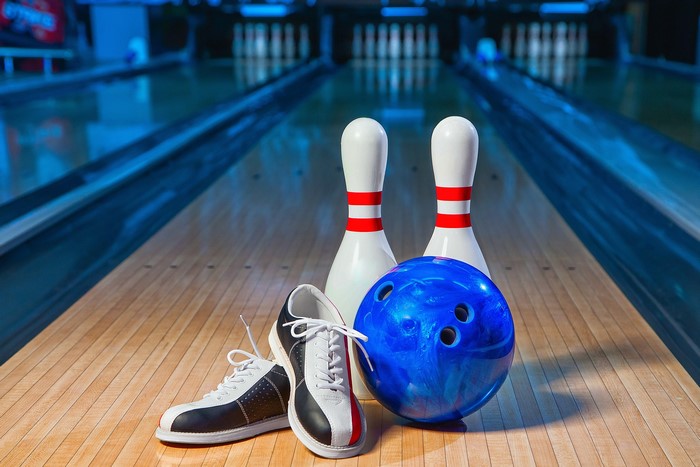 Bowling ball, pins, and shoes on lane