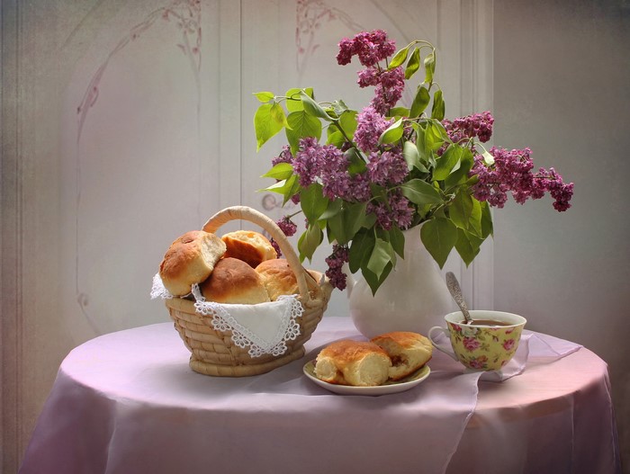 Still life with lilac, pastry, and tea