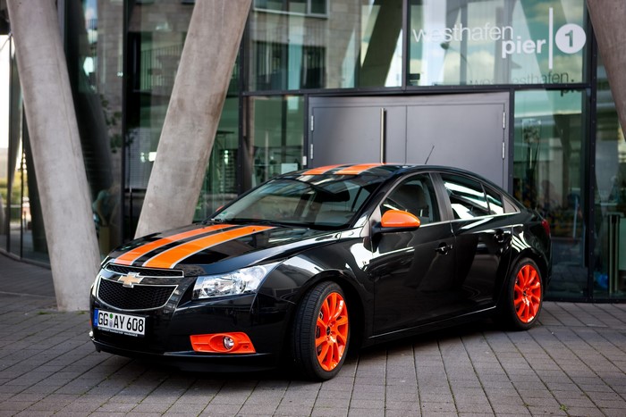 Black Chevrolet Cruze with orange stripes and wheels