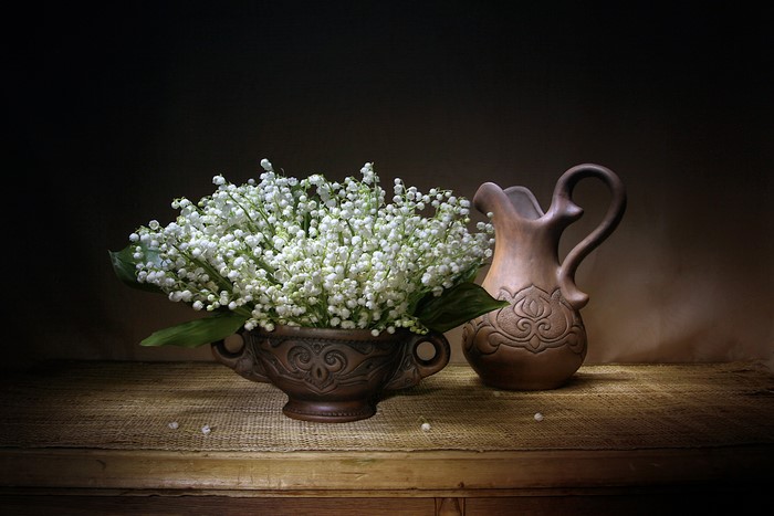 Lily of the valley in a vase with a jug