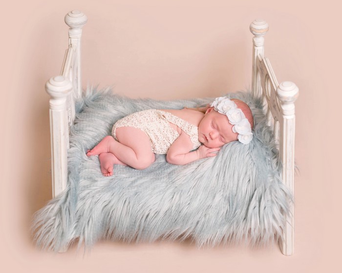 Newborn baby sleeping on a bed