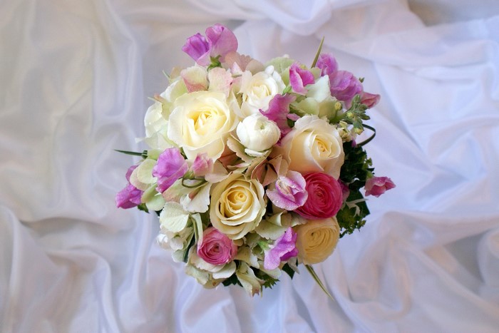 Bouquet of Roses and Ranunculus on White Fabric