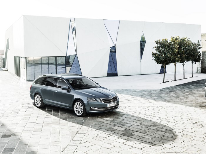 Grey Skoda Station Wagon parked near modern building