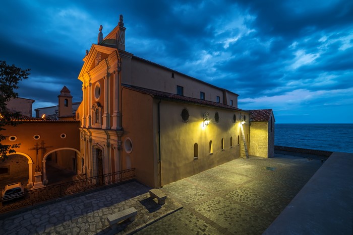 Church with street lights by the sea at dusk