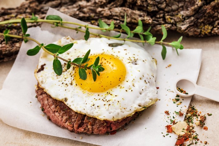 Meat patty with fried egg and herbs