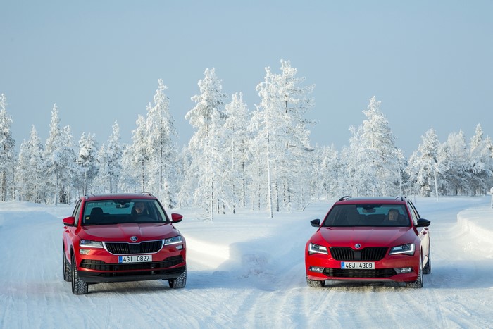 Two red Skoda cars in a snowy forest