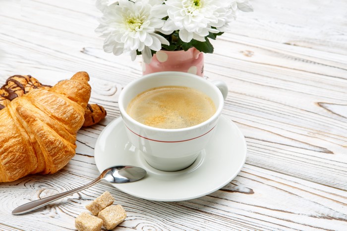 Coffee cup with croissants and flowers