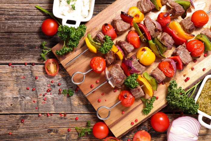 Meat and vegetable skewers on a wooden board