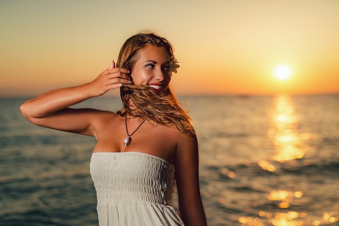 Woman with flower in hair at sunset