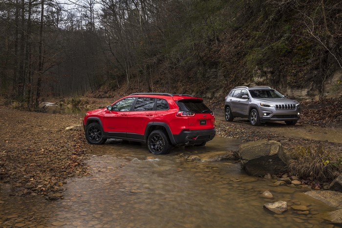 Two Jeep Cherokees driving through a stream