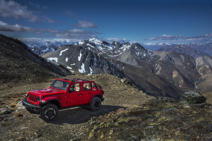 Red Jeep Wrangler Unlimited Rubicon on a mountain road