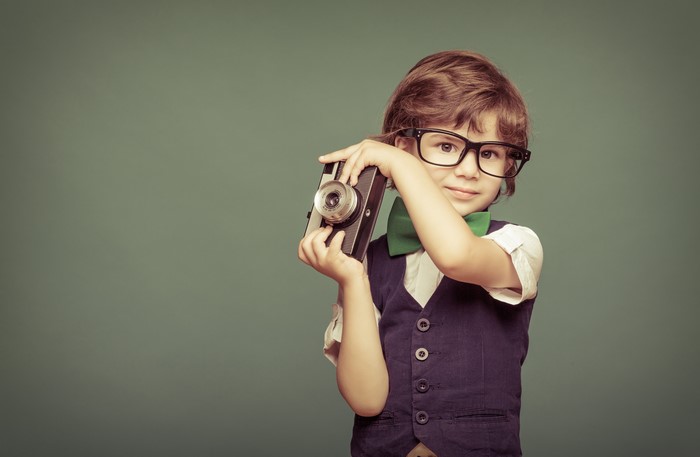 Boy with vintage camera and glasses