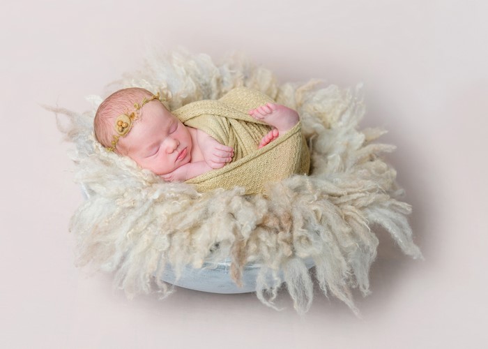 Newborn baby sleeping in a fluffy nest