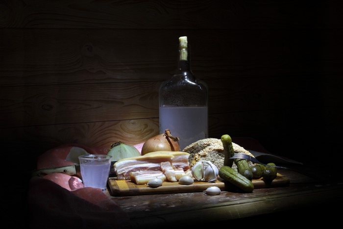 Still life with vodka, salo, bread, and pickles