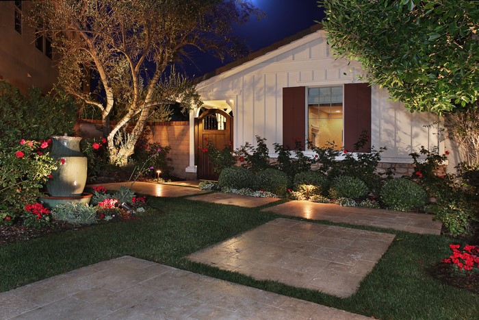 House exterior at night with garden and fountain