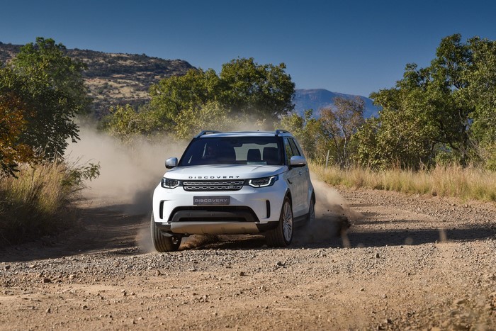 White Land Rover Discovery driving on a dirt road