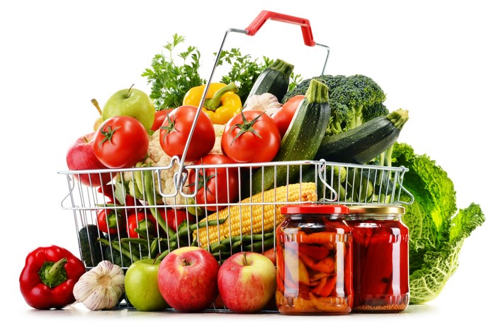 Vegetables and fruits in a shopping basket with jars