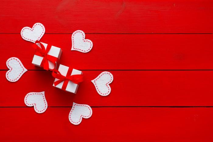 Gifts and hearts on red wooden planks