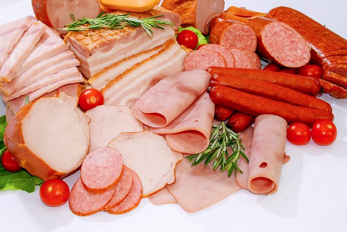 Assortment of cured meats and sausages with tomatoes
