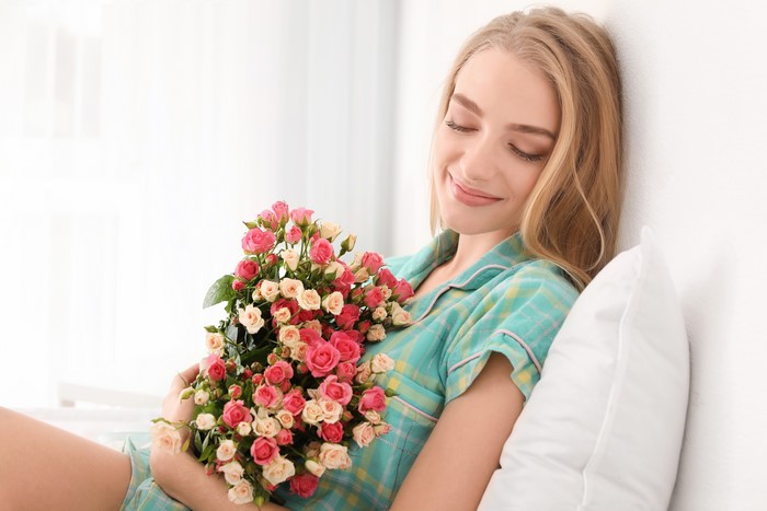 Blonde girl holding a bouquet of roses