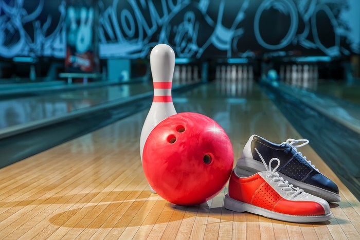 Bowling ball, pin, and shoes on lane