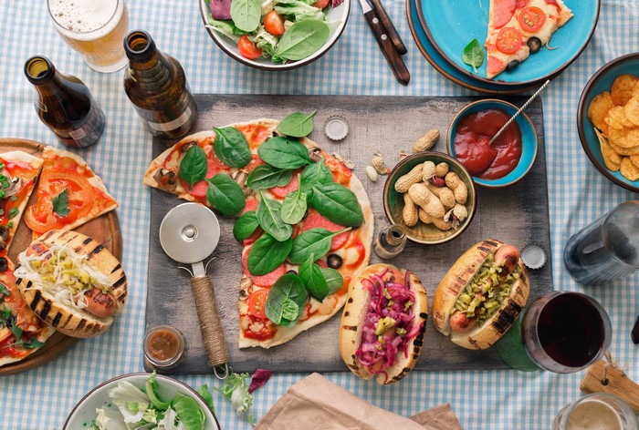 Pizza, Hot Dogs, Nuts, and Beer on a Table