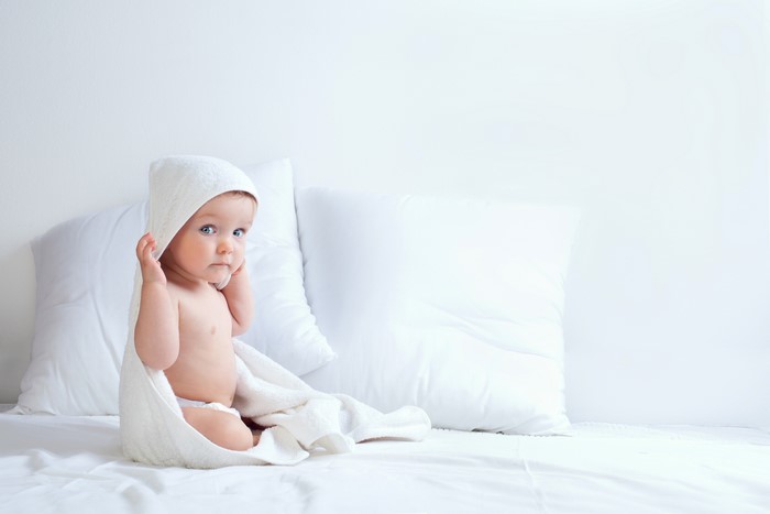 Infant wrapped in a towel with pillows