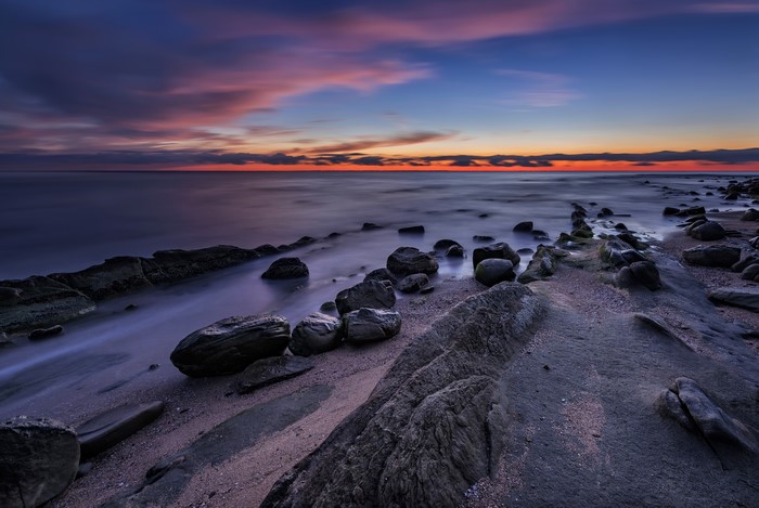 Sunset over the sea coast with stones