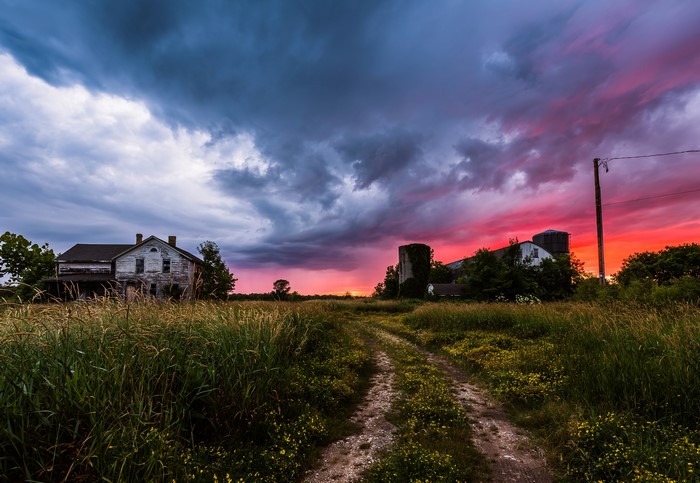 Abandoned farmhouse and silos at sunset in Ozaukee, Wisconsin