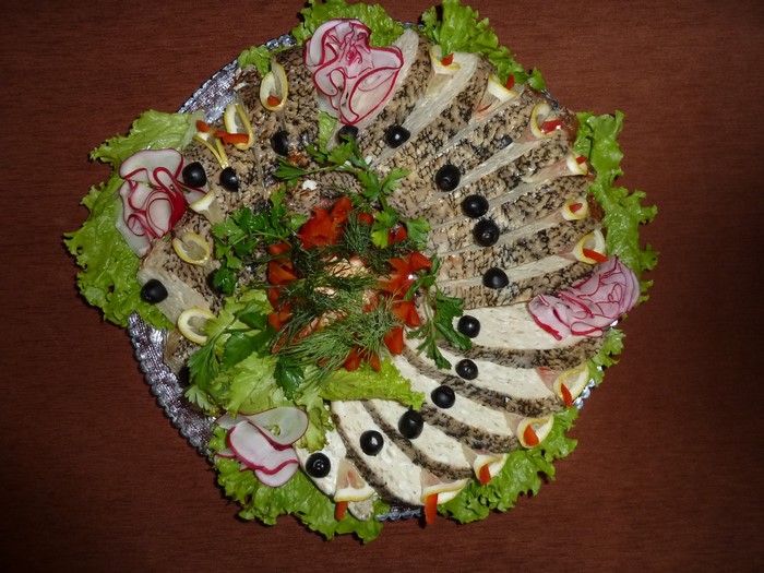 Sliced fish platter with olives, radishes, and lemon