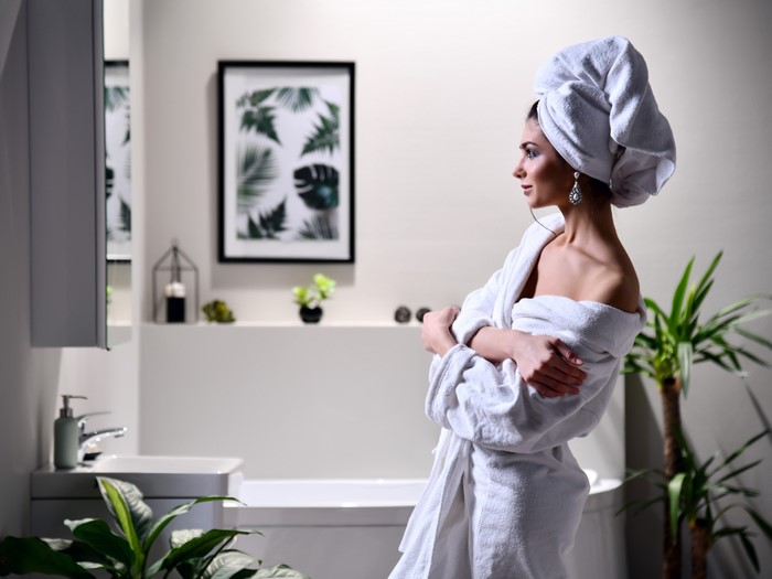 Woman in a bathrobe and towel in a bathroom