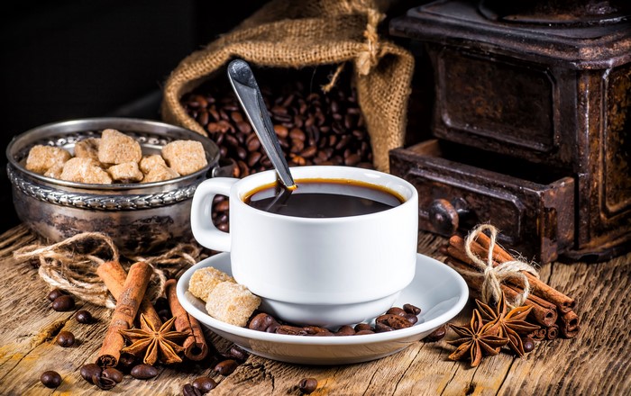 Coffee cup with sugar cubes, cinnamon, and star anise