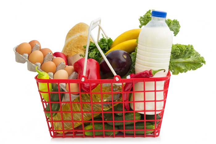 Grocery basket with eggs, milk, bread, and vegetables