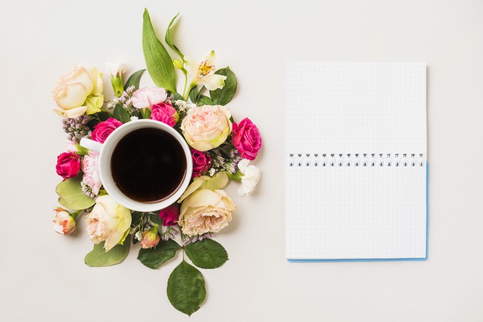 Coffee cup with roses and a notepad