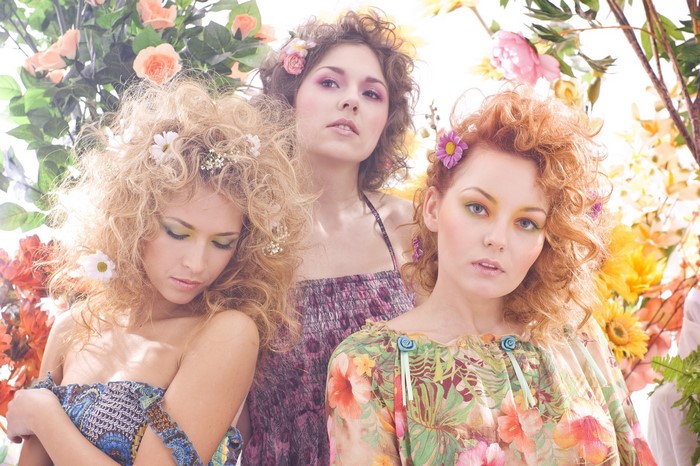Three women with flowers in their hair and floral dresses