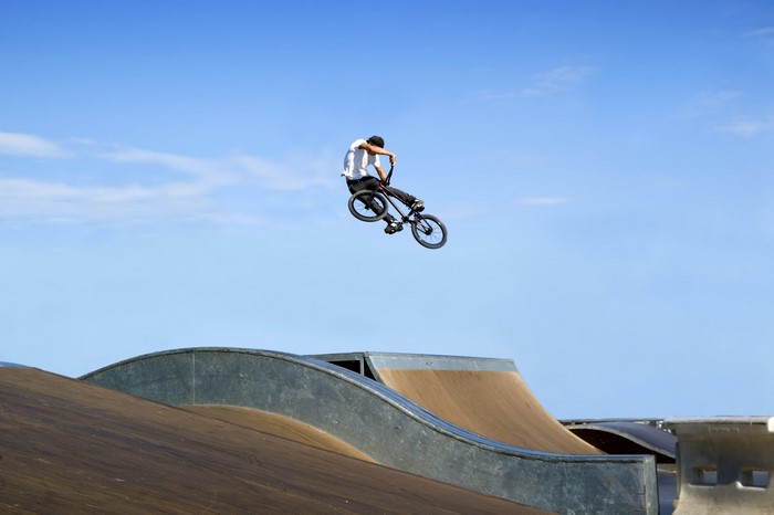 BMX rider performing a jump over ramps