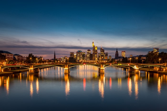 Frankfurt skyline and bridges over river at dusk