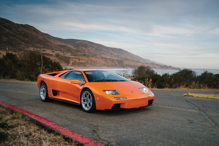 Orange Lamborghini Diablo VT 6 on a coastal road