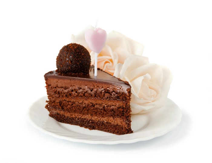 Slice of Chocolate Cake with Heart Candle and Roses