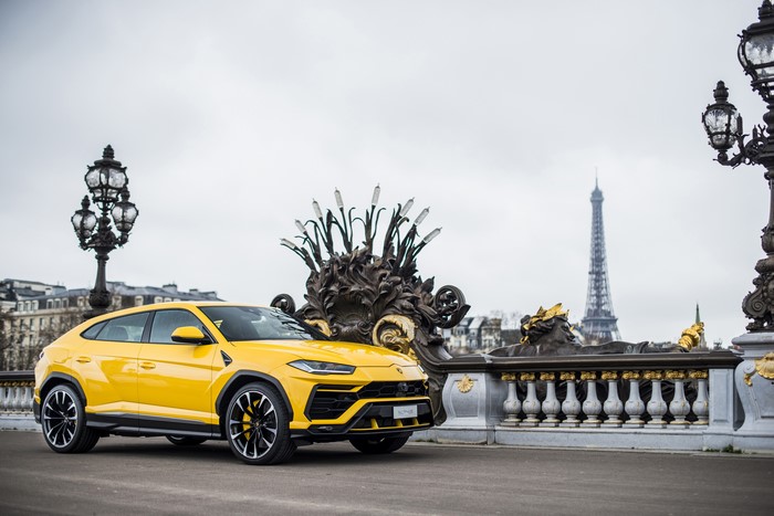 Yellow Lamborghini Urus on a bridge in Paris